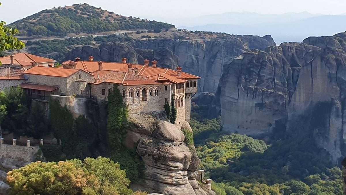 Landscape view of the detailed stone Monastery of Rousanou with tile roofs, built on a central rock pillar in Meteora, Greece