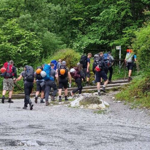 Hikers setting out on the trail to the summit of Olympus, with helmets and protective gear.